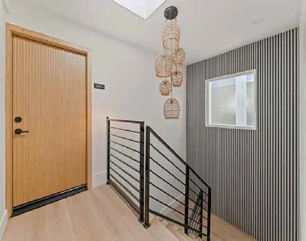 Renovated entry with wood door and metal stair rail