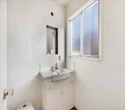 Bathroom sink and mirror before renovation